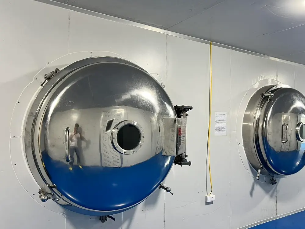 Industrial freeze-drying vessel with its loading door open at the KHAMACO facility.