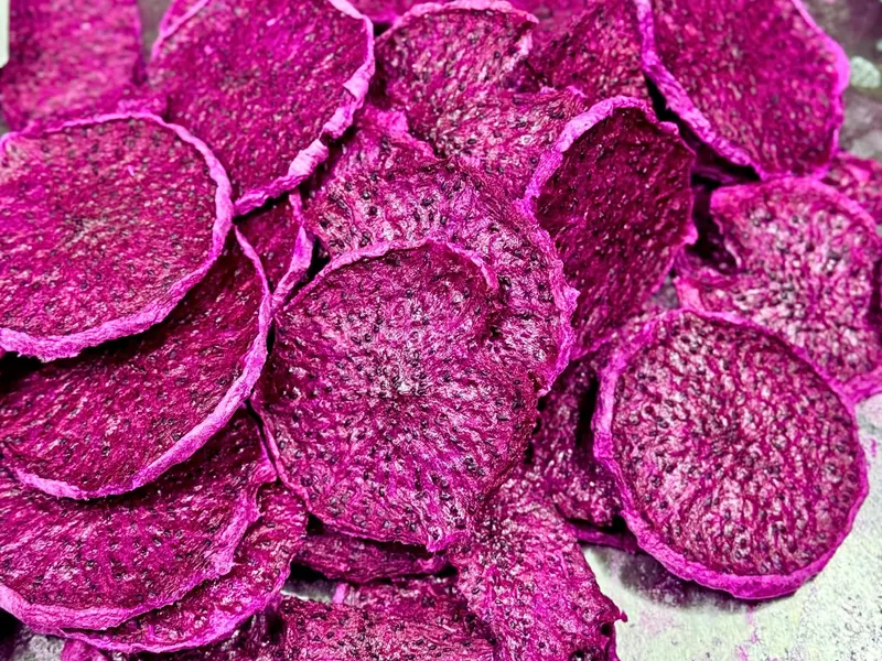Round freeze-dried red dragon fruit chips stacked to fill the frame.