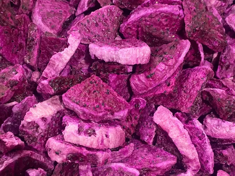 Heap of freeze-dried red dragon fruit slices in varying pink tones.