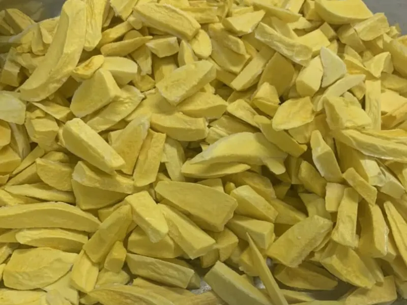 Frame-filling pile of thin pale freeze-dried mango slices.