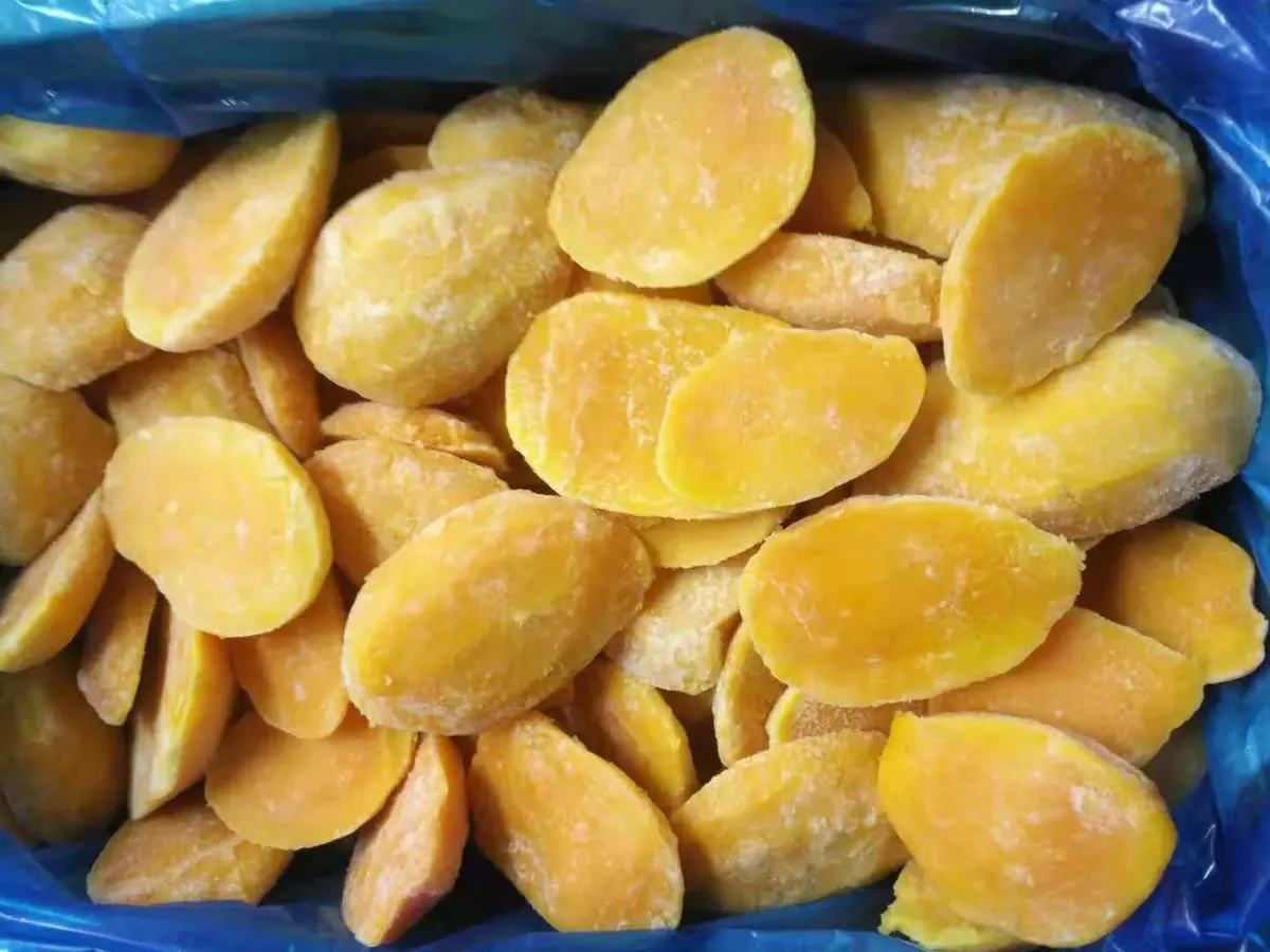 Frost-dusted frozen mango cheeks filling a blue-lined bulk box.