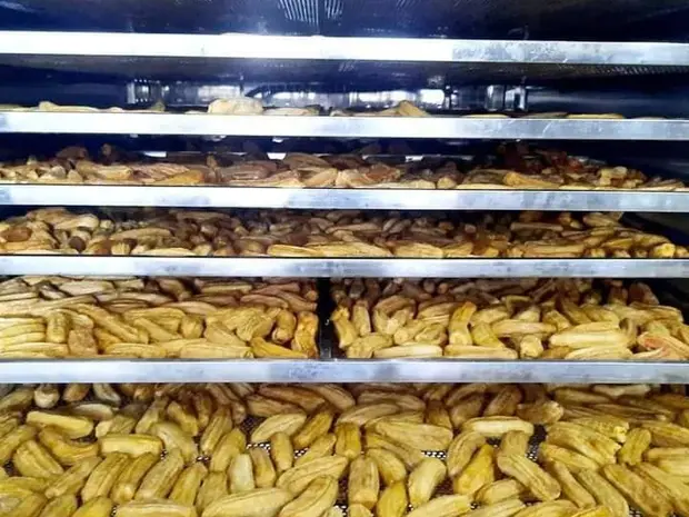 Stacked drying trays of banana inside a hot-air drying chamber.