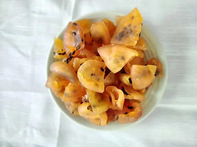Pale bowl of amber soft-dried passion fruit pieces on white cloth