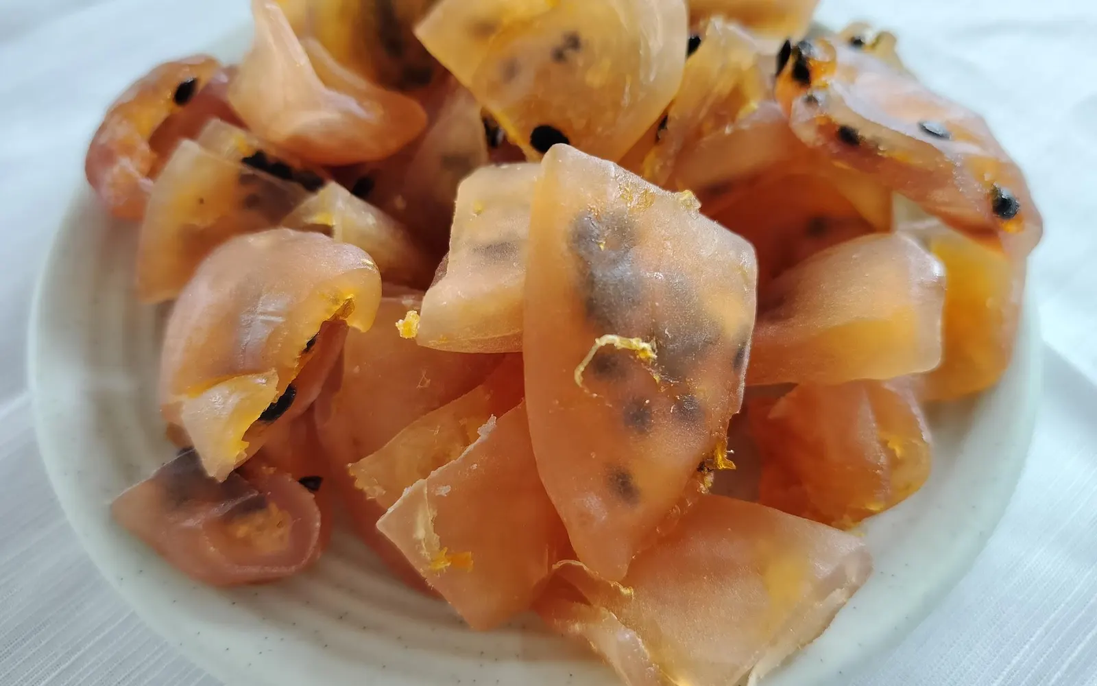 Close-up bowl of translucent amber soft-dried passion fruit with black seeds